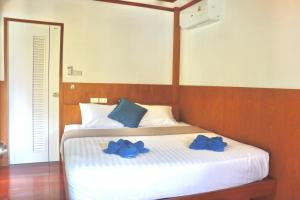 a bed with two blue flowers on top of it at Mook Happy Bungalow in Ko Mook