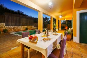 a dining room table and chairs in a patio at "Orange Tree Villa in Alvor - South - facing Family Villa with Private Poll" in Alvor