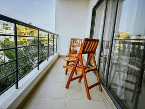 a wooden chair sitting on top of a balcony at Villa EWA in Cotonou