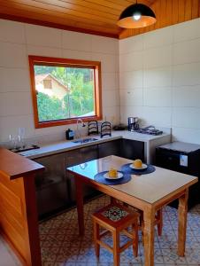 a kitchen with a table with two plates on it at Chalés da Preguiça in Pedra Menina