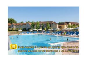 a swimming pool at a resort with people in it at Charmant Appartement avec piscine. in Monflanquin