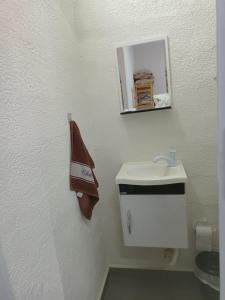 a white bathroom with a sink and a mirror at Chalé do Mamute in Atibaia +8 photos