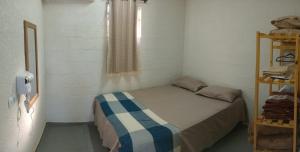 a small bedroom with a bed and a window at Chalé do Mamute in Atibaia