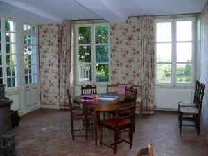 a dining room with a table and chairs and windows at Manoir de Pincelu in La Courbe +23 photos