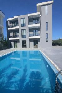 a building with a swimming pool in front of a building at Hotel Sisana in Vlorë