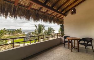 a balcony with a table and chairs and a view of the ocean at El Secreto Residencial in Zihuatanejo