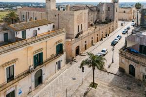 a city street with buildings and a palm tree at Piazzetta San Giovanni Specchia in Specchia