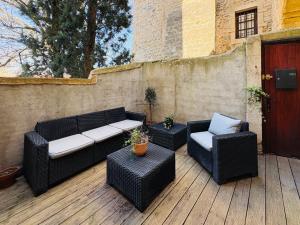 a patio with two chairs and a couch and tables at Studio, terrasse & cathédrale in Valence