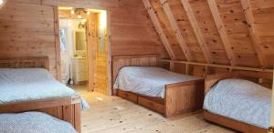 a log cabin with two beds in a room at Whitewater Cottage & RV Resort in Foresters Falls
