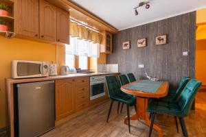 a kitchen with a table and chairs and a microwave at Apartamenty Sawino 4 in Tykocin