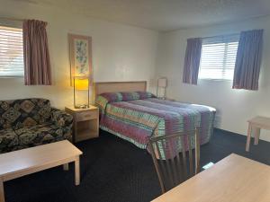 a hotel room with a bed and a couch at Flamingo Suites in Tucson