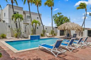 a swimming pool with lounge chairs and a building at Alto Vista 63 in Noord