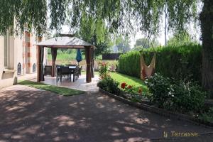 a garden with a gazebo and a table and chairs at Gite Logis des Fontaines in Raon-lʼÉtape