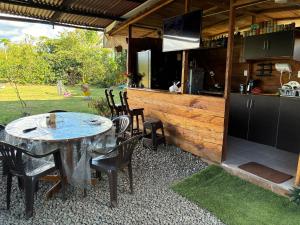 a patio with a table and chairs and a kitchen at cabaña hotel oasis in Montenegro