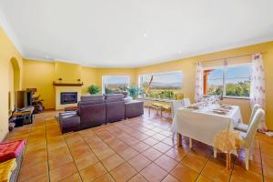 a living room with a table and a couch at "Orange Tree Villa in Alvor - South - facing Family Villa with Private Poll" in Alvor