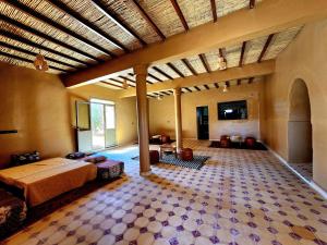 a large room with a bed and a tiled floor at Hamada Kem-Kem Tafraoute in Tafraoute Sidi Ali