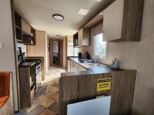 a kitchen with wooden cabinets and a counter top at Caravan Turnberry 2 , Seton Sands, Wifi in Port Seton