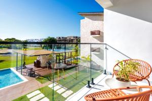 a balcony with a table and chairs and a swimming pool at Elegant 3BD Condo in Cocotal in Punta Cana +37 photos