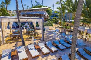 a beach with chairs and a tent and palm trees at Elegant 3BD Condo in Cocotal in Punta Cana