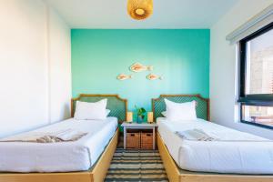 two beds in a room with blue walls at Elegant 3BD Condo in Cocotal in Punta Cana