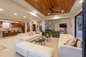 a living room with white couches and a kitchen at NEW! Oceanview, Infinity Pool, Spacious & Private Luxury Group Retreat in Potrero