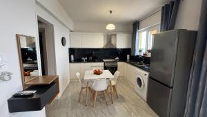 a kitchen with a white table and a refrigerator at Katrin chios in Chios