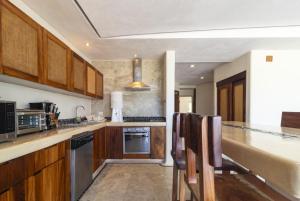 a kitchen with wooden cabinets and a counter top at El Secreto Residencial in Zihuatanejo