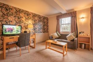 ein Wohnzimmer mit Sofa und Fernseher in der Unterkunft George Hotel in Hexham