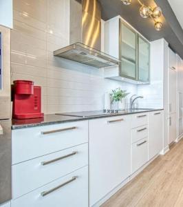 a kitchen with white cabinets and a red appliance at Luxury Cityscape Condo in Toronto