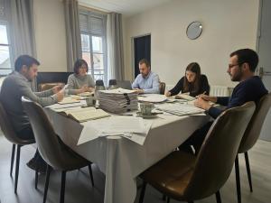 Eine Gruppe von Menschen sitzt um einen Tisch in der Unterkunft Escal Hôtel in Étaples