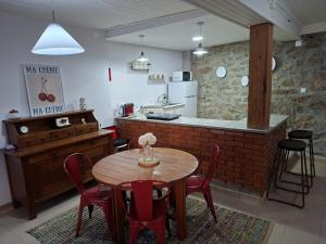 a kitchen with a wooden table and red chairs at Big Alface - Casa de Cima in Trinta