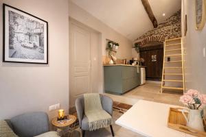 a living room with a table and chairs and a kitchen at L'Amaryllis, suite romantique Jacuzzi et Parking in Cintegabelle
