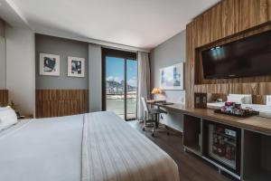 a hotel room with a bed and a desk and a television at Pestana Rio Atlantica in Rio de Janeiro
