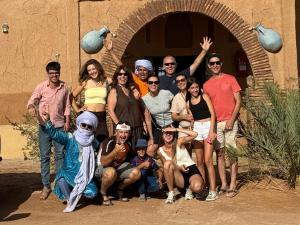 a group of people posing for a picture in front of a building at Hamada Kem-Kem Tafraoute in Tafraoute Sidi Ali +23 photos