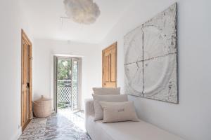 a white living room with a couch and a picture at La Bâtisse en Blanc in Golfe-Juan +65 photos