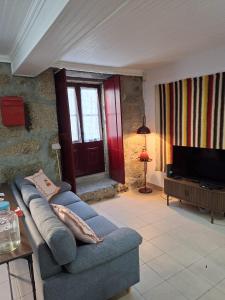 a living room with a blue couch and a tv at Big Alface - Casa de Cima in Trinta
