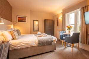 ein Hotelzimmer mit Bett, Tisch und Stühlen in der Unterkunft George Hotel in Hexham