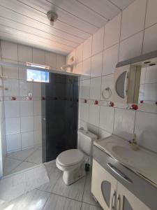 a bathroom with a toilet and a sink at Aconchego do Lar Hostel in Palhoça +26 photos