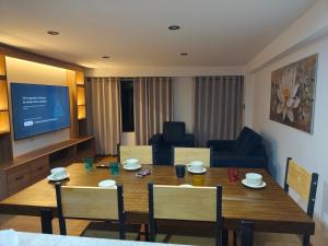 a living room with a table and chairs and a television at Casa Karmenka in Cusco