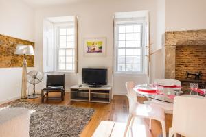 a living room with a table and a television at São Mamede Downtown Apartment in Lisbon