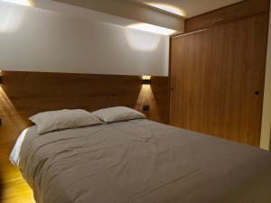 a bedroom with a large bed with a wooden headboard at Casa Karmenka in Cusco