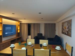 a living room with a dining table and a television at Casa Karmenka in Cusco