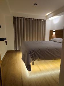 a bedroom with a bed and a window with curtains at Casa Karmenka in Cusco
