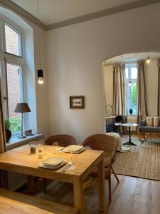 a dining room table with chairs and a living room at Altstadtrefugium "Backsteenhuus" und ,,Li ebertee" in Leer in Leer