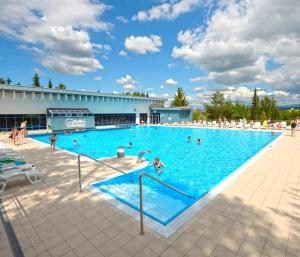 a large swimming pool with people in the water at ChataKováčová in Kováčová