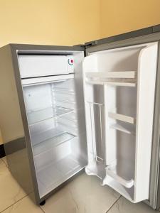 an empty refrigerator with its door open in a kitchen at Zanzibar Apartment 1 in Kibele