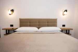 ein Schlafzimmer mit einem großen Bett und zwei Nachttischen in der Unterkunft Sky Touch Suites Napoli in Neapel
