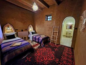 a room with two beds and a ladder in it at Hamada Kem-Kem Tafraoute in Tafraoute Sidi Ali