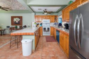 a kitchen with wooden cabinets and a stainless steel refrigerator at Spacious Beachfront Condo Las Palmas II 11A in Puerto Peñasco