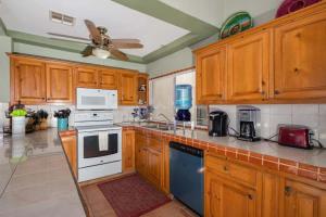 a kitchen with wooden cabinets and white appliances at Spacious Beachfront Condo Las Palmas II 11A in Puerto Peñasco